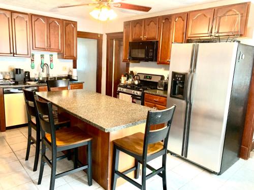 eine Küche mit einem Kühlschrank und einem Tisch mit Stühlen in der Unterkunft Cozy First Floor Apartment in Chicopee