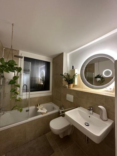 a bathroom with a sink and a toilet and a tub at Stylish Apartment Balcony 2 BR Central in Kaiserslautern