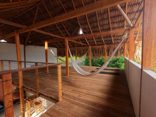a hammock in the middle of a room with wood floors at Casa Matilda - Palomino in Palomino
