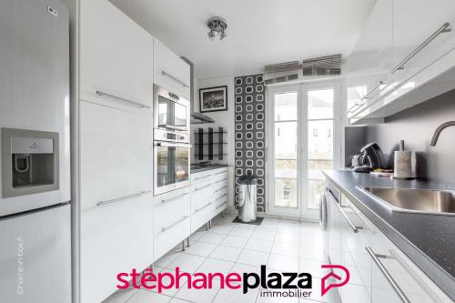 une cuisine blanche avec un évier et un comptoir dans l'établissement La Médina by Plaza - Proche Disneyland Paris, à Serris