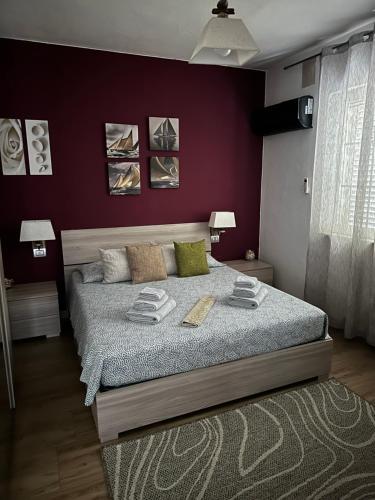 1 dormitorio con 1 cama grande y paredes moradas en Beppo's B&B en Carbonia