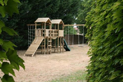 a wooden playground with a slide in a yard at Charme en Champagne in Trémilly