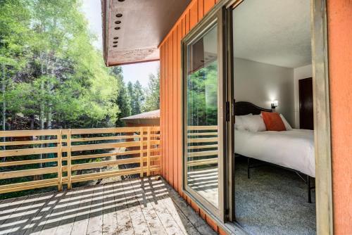 eine Glastür, die zu einem Schlafzimmer mit einem Bett auf dem Balkon führt in der Unterkunft Geyser Getaway in West Yellowstone