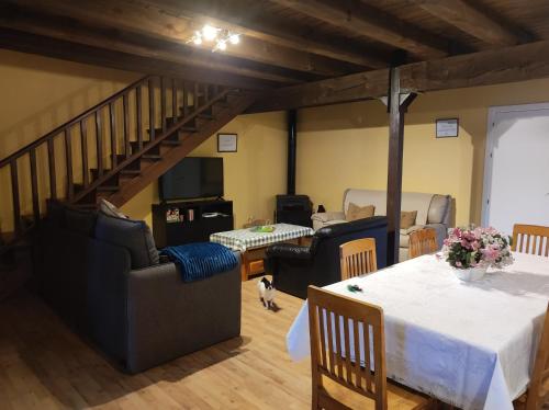 ein Wohnzimmer mit einem Tisch und einer Treppe in der Unterkunft Casa rural La Gata in Campillo de Ranas