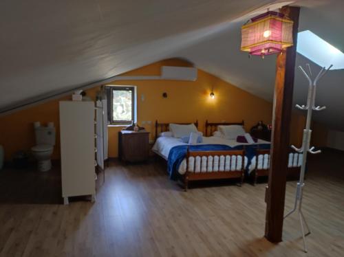 a bedroom with a bed and a lamp in a attic at Casa rural La Gata in Campillo de Ranas