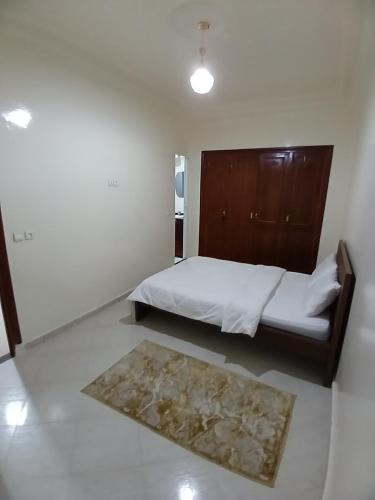Dormitorio pequeño con cama y alfombra en Chambre Royale Avec toilette Interne, en Casablanca