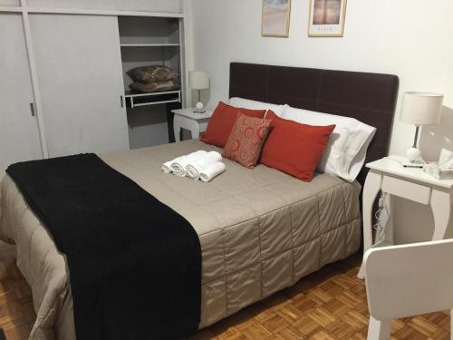 um quarto com uma cama grande e almofadas vermelhas em Palermo Botánico em Buenos Aires