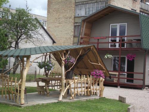 a picnic table and chairs in front of a building at Nakvynė Rokiškyje in Rokiškis