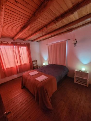 1 dormitorio con 1 cama y 2 mesas. en Plaza San Fernando en San Martín de los Andes