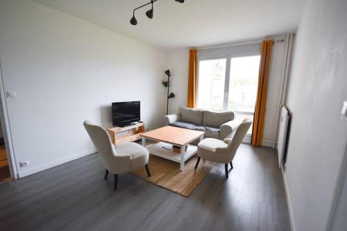 een woonkamer met een tafel en stoelen bij Logement individuel ROUEN in Le Petit-Quevilly