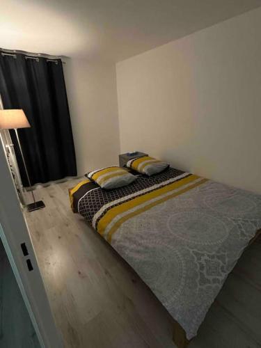 een slaapkamer met een bed met 2 kussens erop bij Logement individuel ROUEN in Le Petit-Quevilly