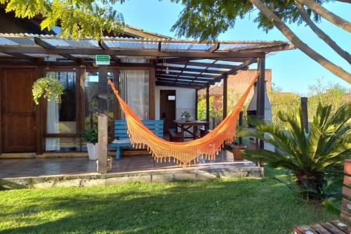 a hammock on a porch of a house at Casa Albatroz do Rosa - Albatroz Hospedaria in Imbituba