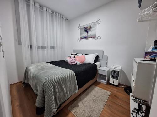 ein Schlafzimmer mit einem Bett mit einer schwarzen Decke und rosa Kissen in der Unterkunft Ponte Laguna, Pq Burle Marx, Apto 1 dorm e Varanda in São Paulo