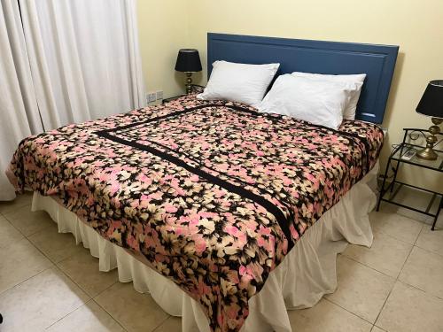 的住宿－R Vision North Cyprus，一间卧室配有一张带花卉床罩和枕头的床