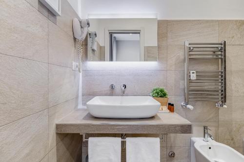 W łazience znajduje się biała umywalka i lustro. w obiekcie Colonna Luxury Suites w Rzymie