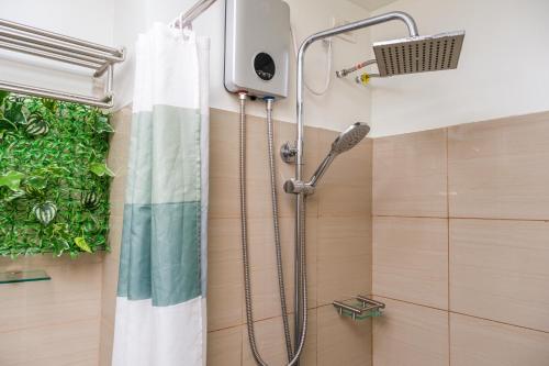 a shower in a bathroom with a shower curtain at 2 Side-by-Side P00L Front Condos, 6 Beds, 2 CR, 2 Kitchen for 10 Guests at MOA in Manila
