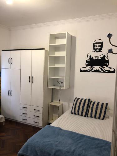 ein Schlafzimmer mit einem Bett und einem Schrank mit einer Meditationsgunigun in der Unterkunft Departamento Pocitos con anfitrión in Montevideo