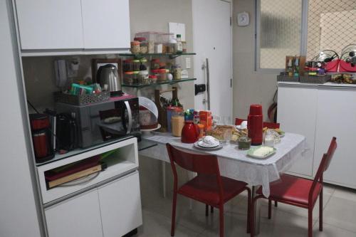 uma cozinha com uma mesa, 2 cadeiras e um micro-ondas em AMPLA e CONFORTÁVEL SUITE - BAIRRO DO ESPINHEIRO - RECIFE no Recife