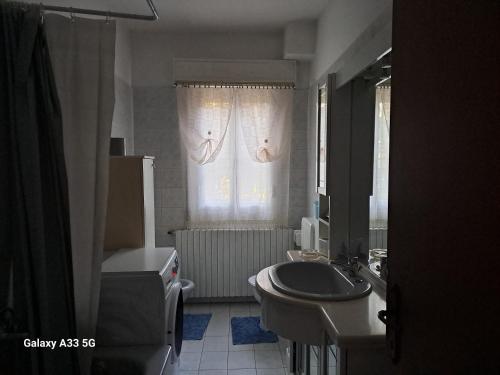 uma casa de banho com um lavatório, um WC e uma janela. em Da Nonna Rosa em Budrio