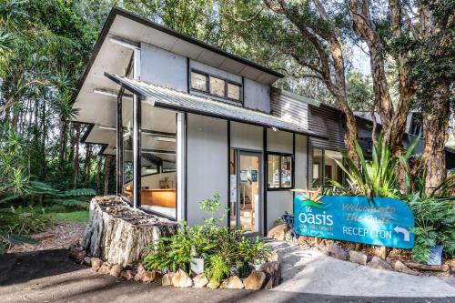 uma casa com um sinal em frente em The Oasis at One Mile Beach em Nelson Bay