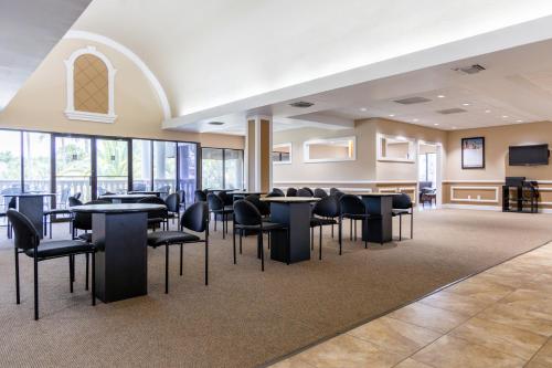 a dining room with tables and chairs and windows at Legacy Vacation Resorts Kissimmee & Orlando - Near Disney in Kissimmee