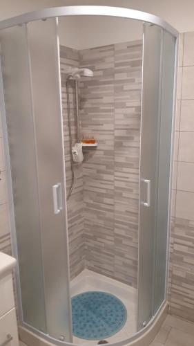 une douche avec une porte vitrée dans une salle de bain dans l'établissement La Dimora di Dora, à Naples