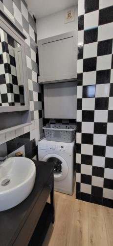 a bathroom with a sink and a washing machine at L'Escale CDG aéroport, Stade de France, Parc des Exposition, PARIS in Villepinte