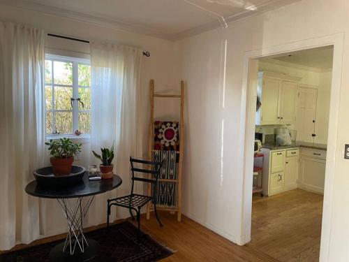 a living room with a table and a kitchen at Gorgeous boho bungalow in the heart of Pasadena in Pasadena