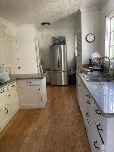 a kitchen with white cabinets and a stainless steel refrigerator at Gorgeous boho bungalow in the heart of Pasadena in Pasadena