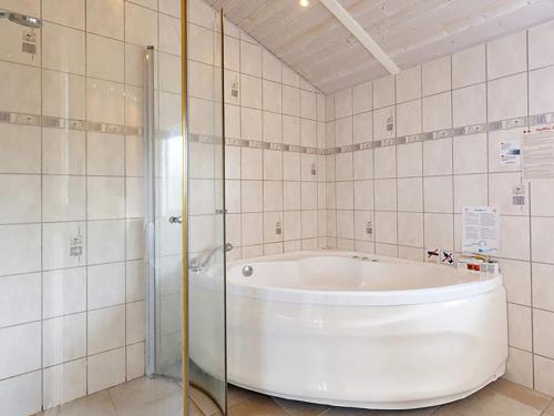 een badkamer met een wit bad en een douche bij 10 person holiday home in Rudk bing in Spodsbjerg