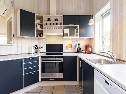 een keuken met blauwe kasten en een wastafel bij 10 person holiday home in Rudk bing in Spodsbjerg