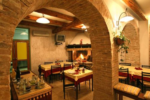 a dining room with tables and chairs and a fireplace at Kastel Kastelir in Kaštelir