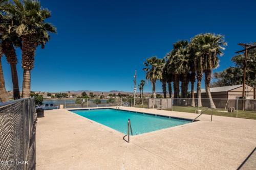 una piscina con palme sullo sfondo di Lower River Retreat a Parker