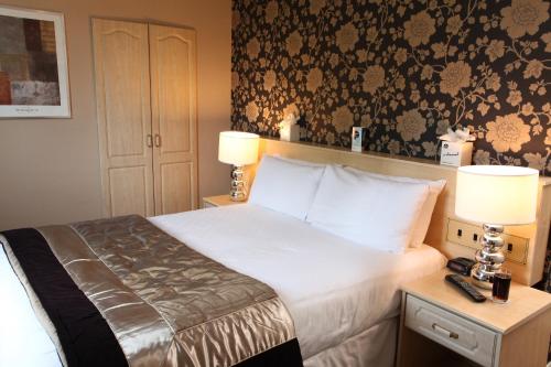 a bedroom with a bed with two lamps and a wall at Best Western New Kent Hotel in Newcastle upon Tyne