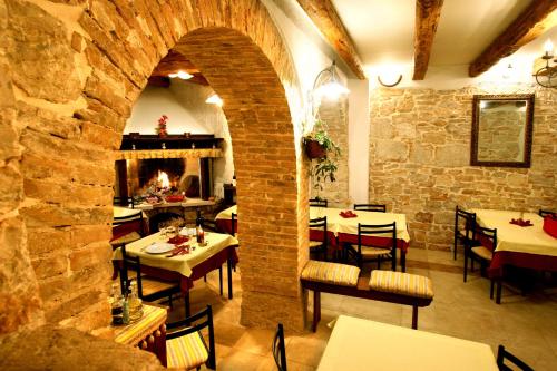 a restaurant with tables and chairs and a brick wall at Kastel Kastelir in Kaštelir