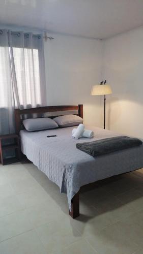 um quarto com uma cama grande e um candeeiro em Hospedaje MV em Coto Brus