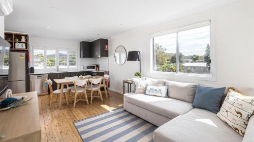a living room and kitchen with a couch and a table at Shoal Bay Beach House Three in Shoal Bay