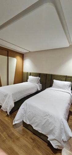 - 2 lits dans une chambre avec des draps blancs dans l'établissement Nouvel appartement luxueux Riad Garden Marrakech, à Marrakech