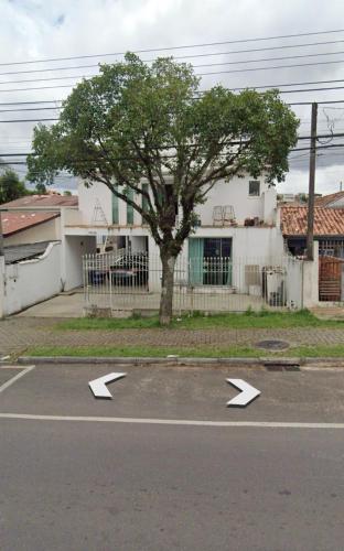 a parking lot with arrow signs in front of a tree at Quarto Hostel Curitiba in Curitiba