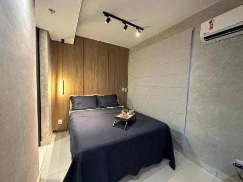 Un dormitorio con una cama con una mesa. en Studio Aconchegante e Completo en Ribeirão Preto