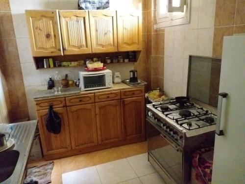 a kitchen with a stove and a microwave at Mourad House in Aswan