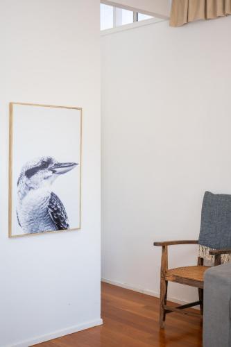 a drawing of a bird in a living room next to a chair at Barrington Riverside Cottages in Barrington