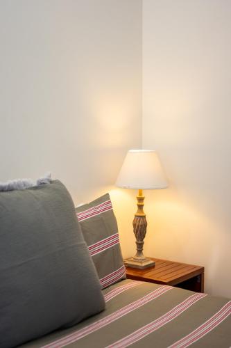 a bedroom with a bed with a lamp on a table at Barrington Riverside Cottages in Barrington