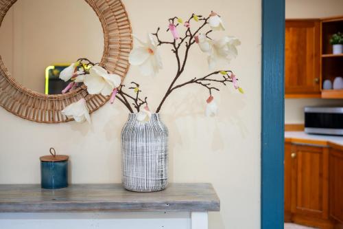 a vase with flowers in it sitting on a table at Barrington Riverside Cottages in Barrington