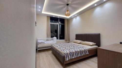a bedroom with a bed and a baby crib in it at Tanger Luxury Family Appartments 2 Hilton Only families in Tangier