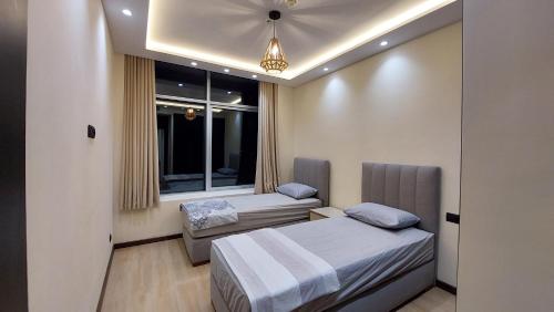 a bedroom with two beds and a couch and a window at Tanger Luxury Family Appartments 2 Hilton Only families in Tangier