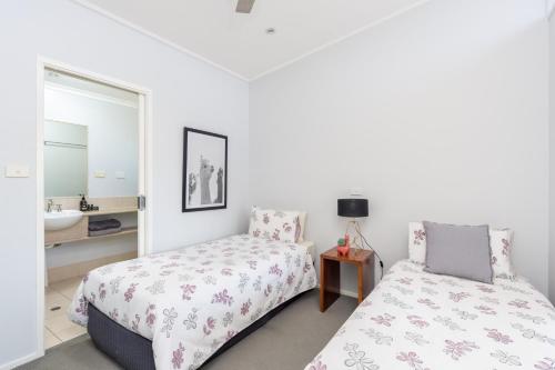 a bedroom with a bed and a sink and a mirror at Barrington Riverside Cottages in Barrington