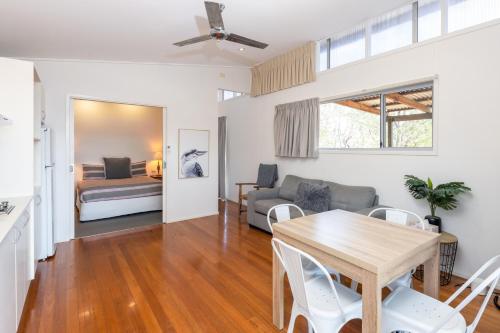 a living room with a table and a couch at Barrington Riverside Cottages in Barrington