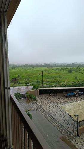 a view of a field from a balcony at Cozy Studio near Bhavali Dam in Igatpuri