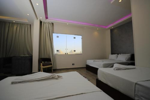 a hotel room with two beds and a large window at Jewel Grand Museum & Pyramids View in Giza